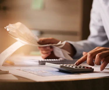 closeup-economist-using-calculator-while-going-through-bills-taxes-office 1